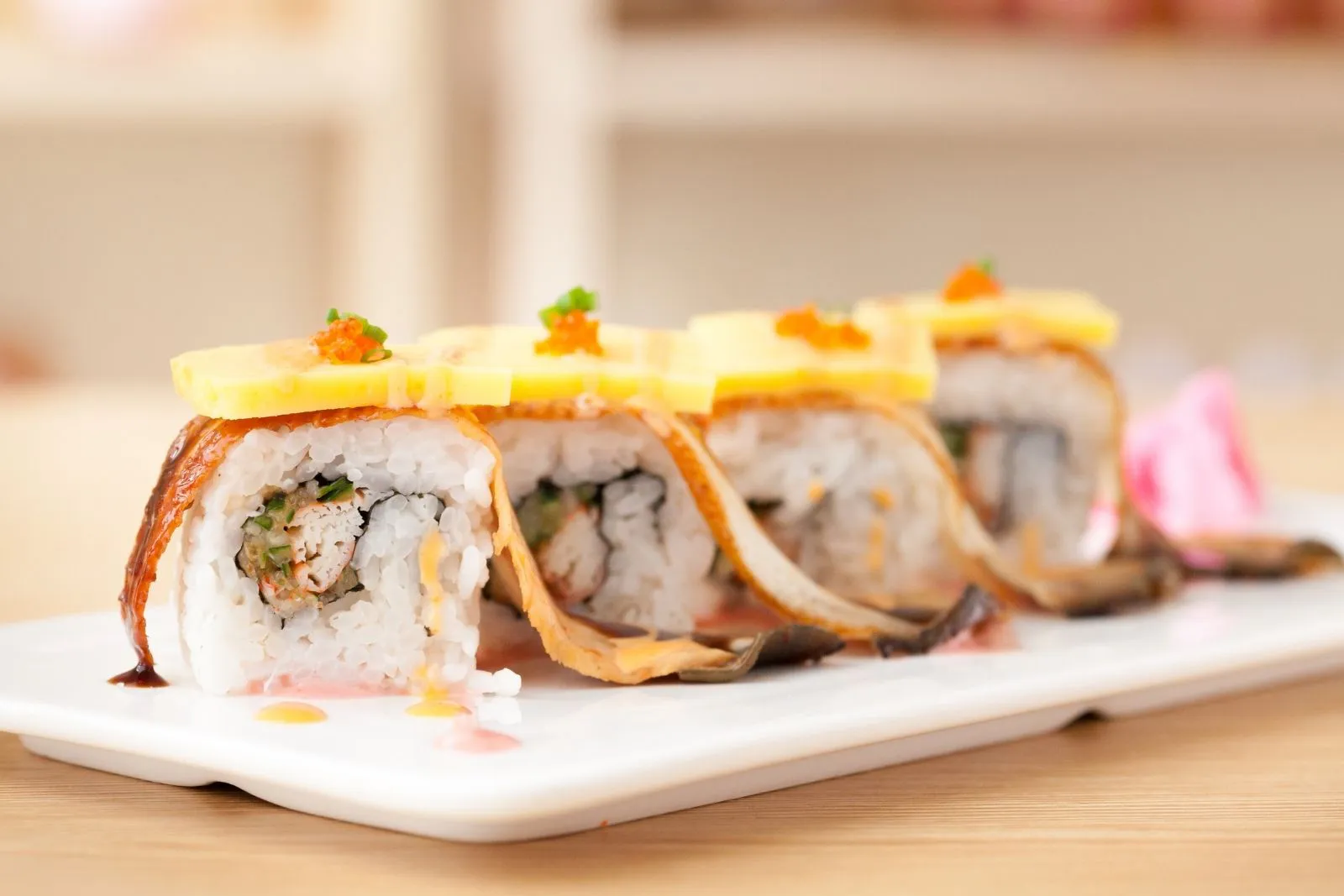 Grilled eel sushi rolls topped with thin yellow cheese and tobiko roe at Teppan Salem Enterprise LLC, a Japanese Restaurant in Salem